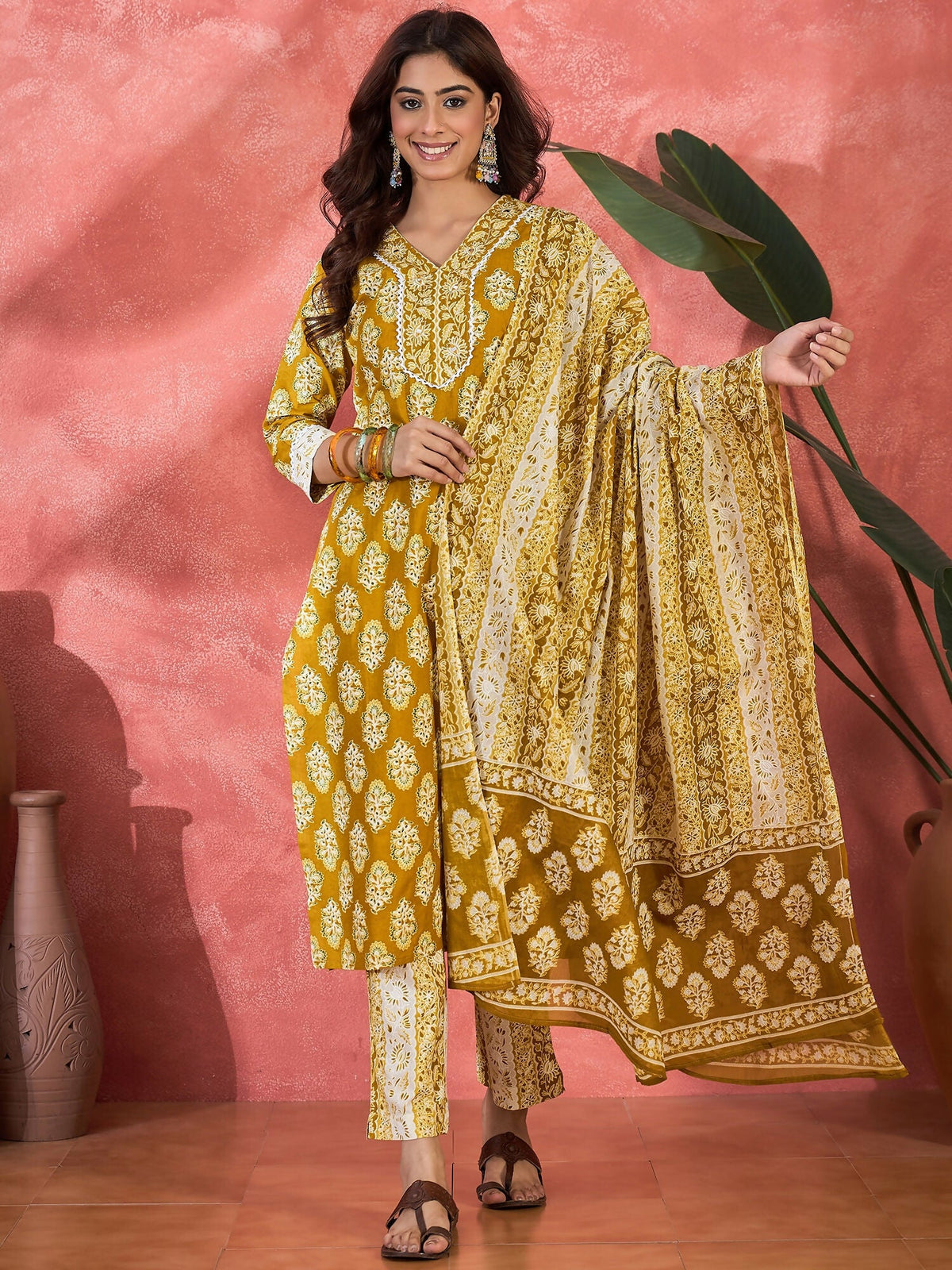 Model wearing a printed mustard pure cotton kurta set with a graceful ethnic design.