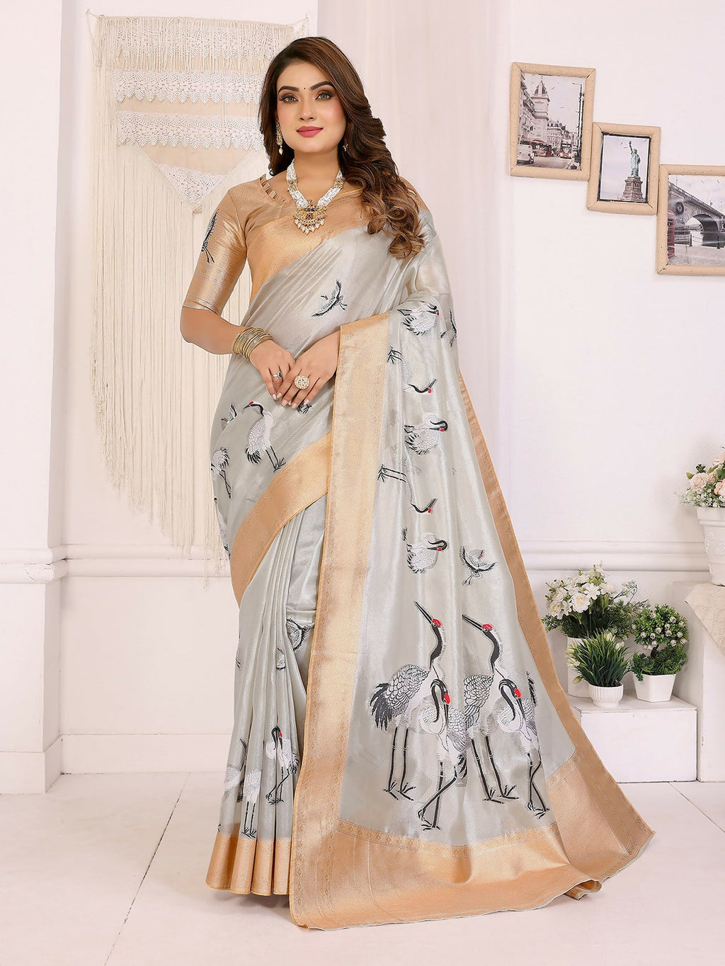 Woman wearing a golden Banarasi silk saree with crane patterns and silver accents
