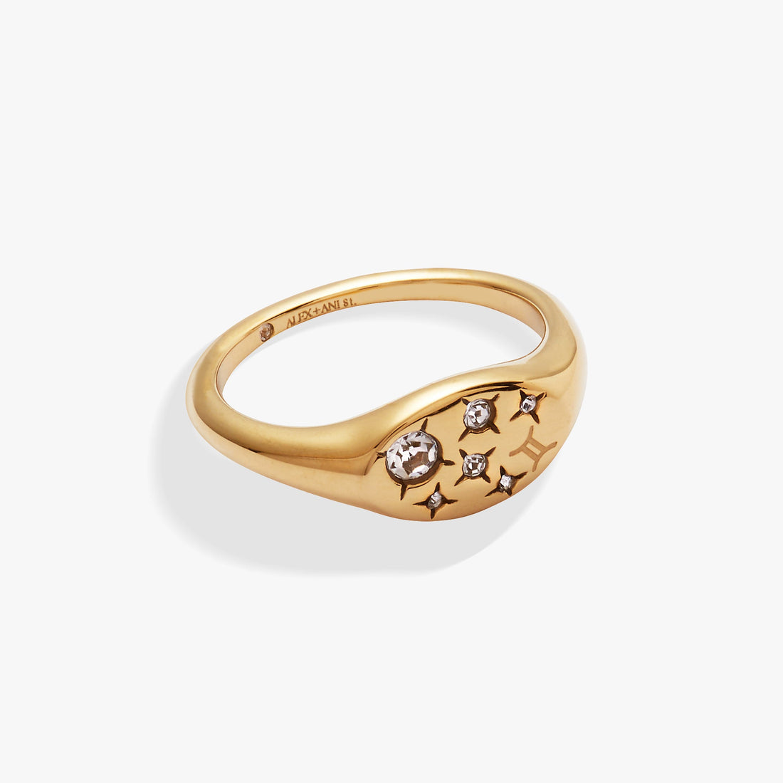 Close-up of a gold-plated Gemini zodiac signet ring with flush-set crystal accents on a model's finger.