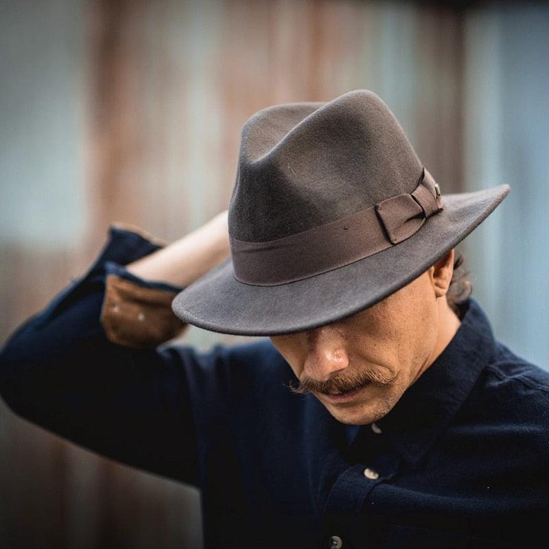 Classic brown men's felt fedora hat with a decorative bow tie, wide brim jazz style.