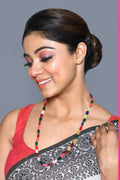 Elegant multi-strand mala necklace featuring vibrant beads and pearls on a neutral background