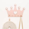 Princess crown shaped wall hooks used to hang hair bows and jewelry in a child's nursery