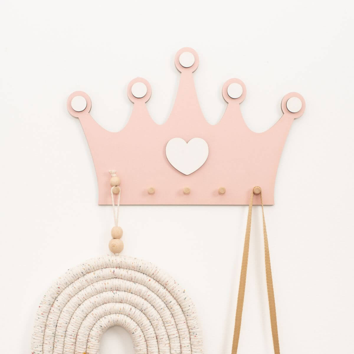 Princess crown shaped wall hooks used to hang hair bows and jewelry in a child's nursery