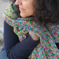 Gleeful Hummingbirds Wrap in grey and multi-color yarn displayed as a finished crochet accessory.