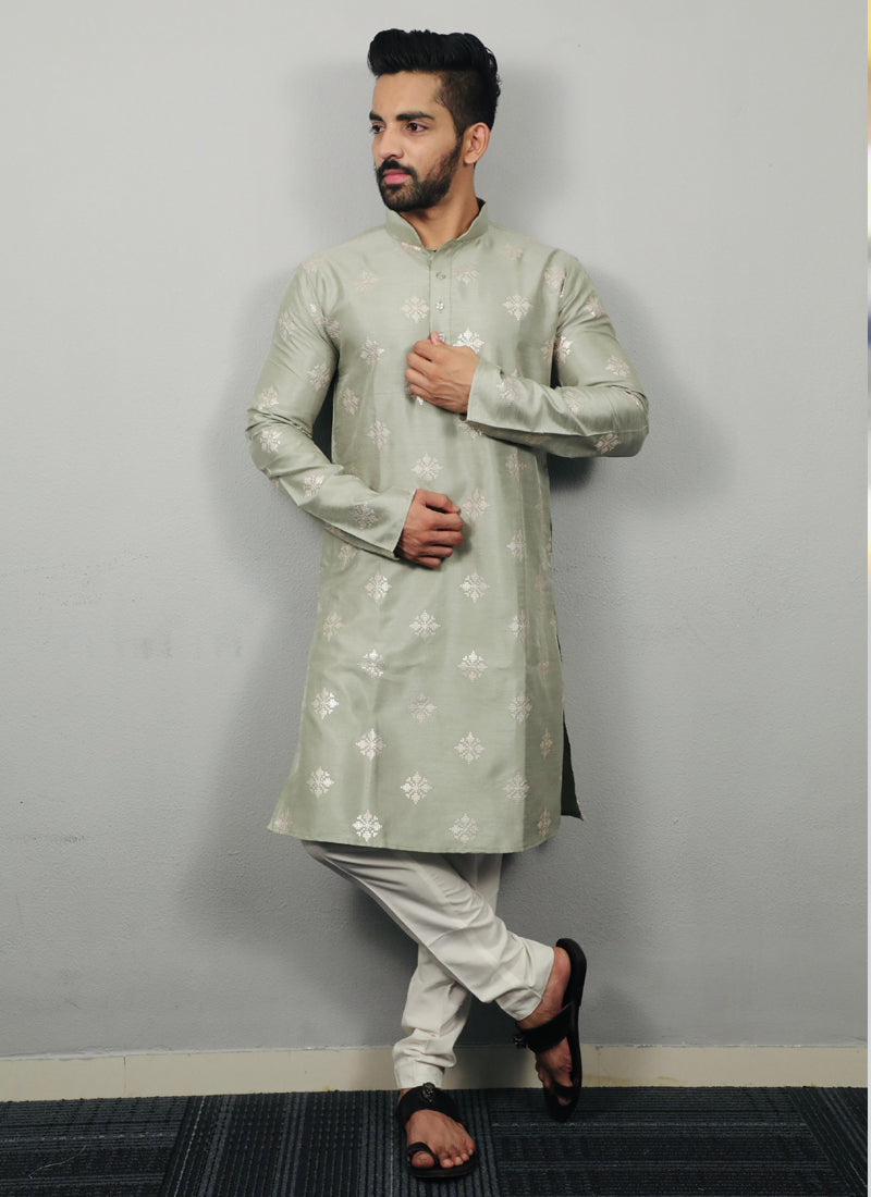 Men wearing a Pista green silk kurta with intricate copper sequence work detailing