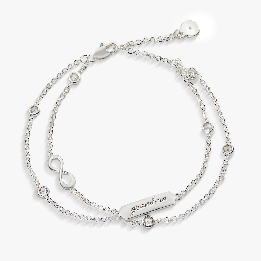 Double strand chain bracelet featuring an infinity symbol charm in gold and silver.