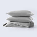 A grey cooling comforter set with matching pillow shams shown on a made bed.