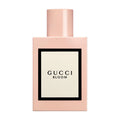 Gucci Bloom Eau de Parfum in a pink and cream bottle against a minimalist background.