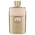 A luxurious gold and pale-pink bottle of Guilty Pour Femme Eau de Parfum standing on a clean surface.