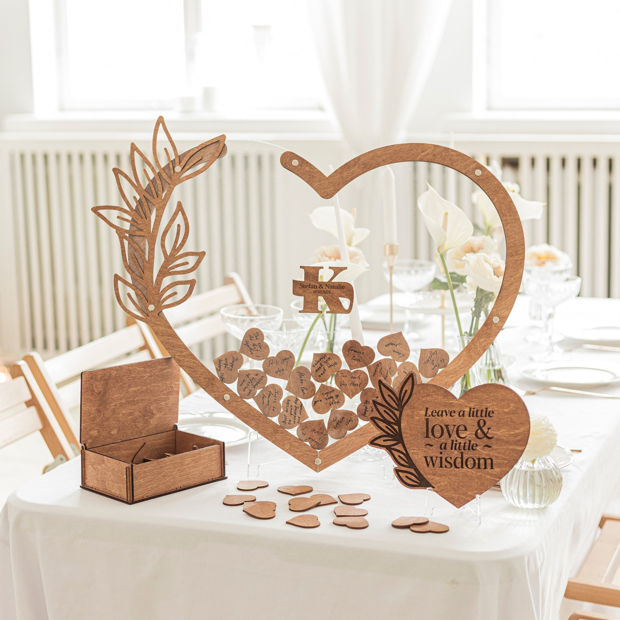 Heart-shaped acrylic wedding guest book sign on a display stand