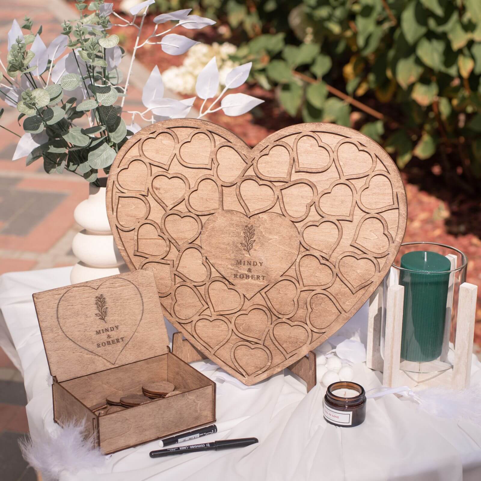 A heart-shaped wooden alternative wedding guest book on a display stand.