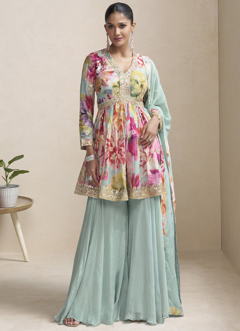 A woman wearing a sea green chinon designer palazzo suit with intricate gota patti embroidery.