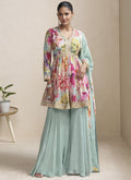 A woman wearing a sea green chinon designer palazzo suit with intricate gota patti embroidery.