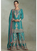Woman wearing a turquoise Chinon designer palazzo suit with intricate gota patti and embroidery