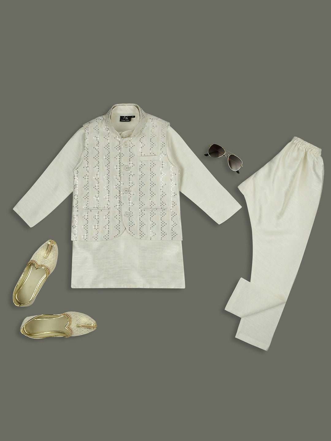 A boys cream-colored kurta and pyjama set paired with a sequence-work Nehru jacket.