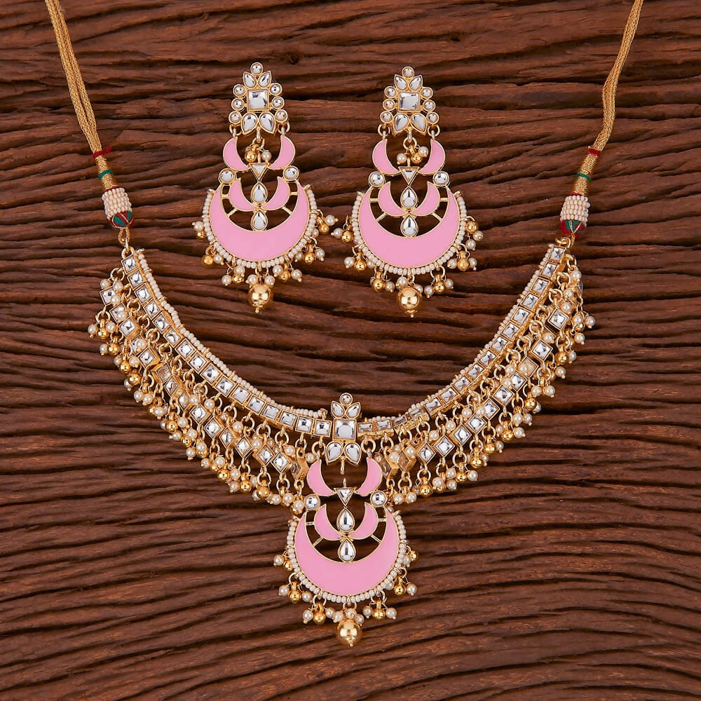 Elegant Golden White Pink Kundan necklace set with pearl and onyx stone detailing displayed on a professional background.