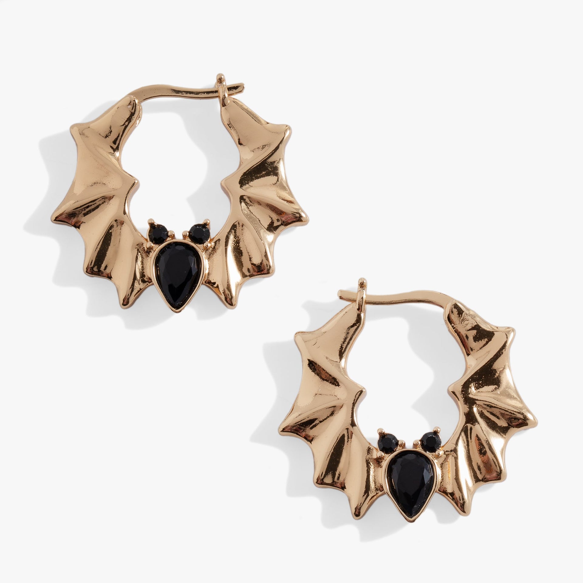 Elegant gold and silver tone hoop earrings featuring black pear-cut crystal bat motifs, gothic-glam style.