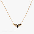 Close up of a silver bat-shaped pendant featuring three black pear-cut crystals on a silver cable chain.