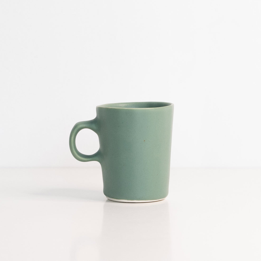 Handmade porcelain espresso cup in muted green and terracotta orange