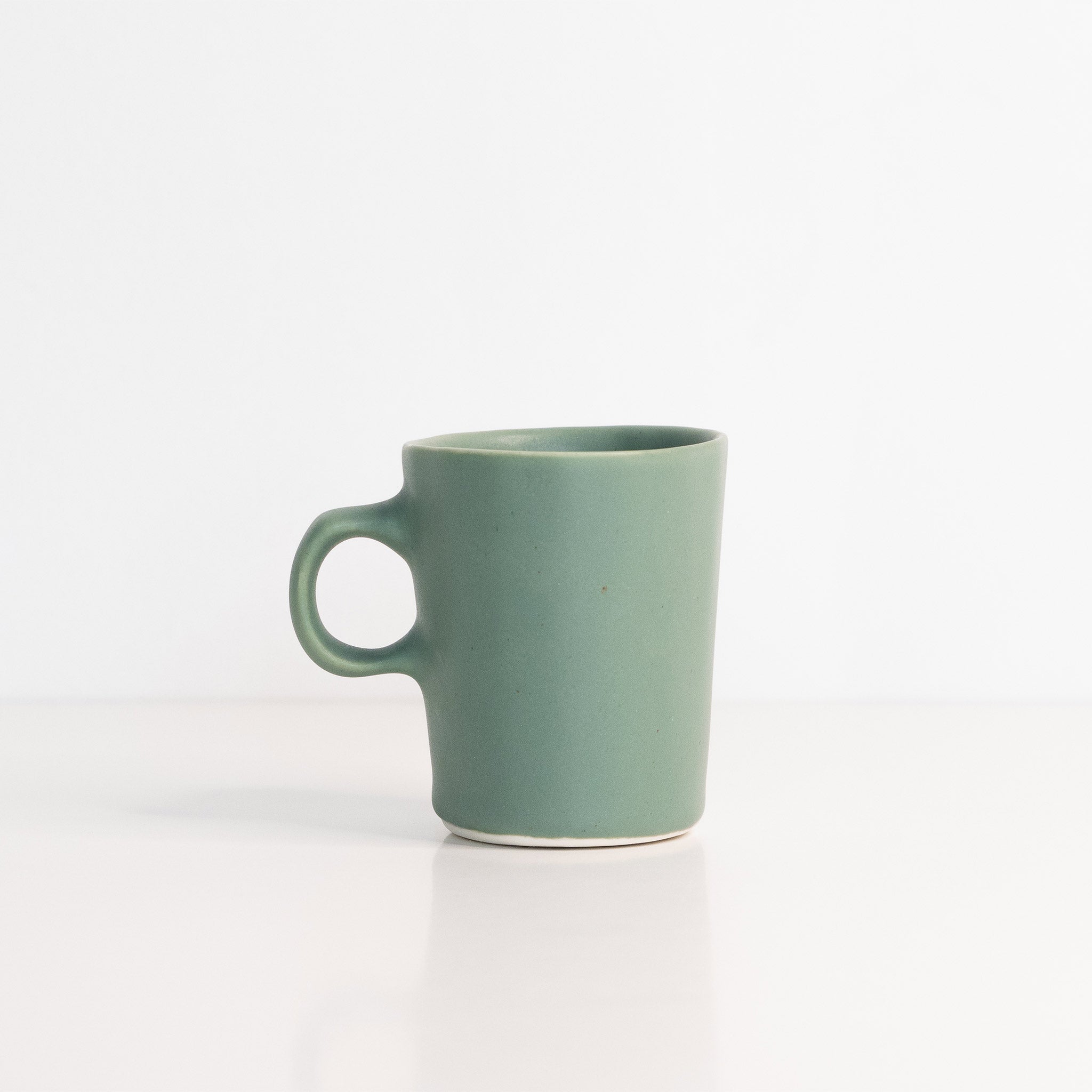 Handmade porcelain espresso cup in muted green and terracotta orange