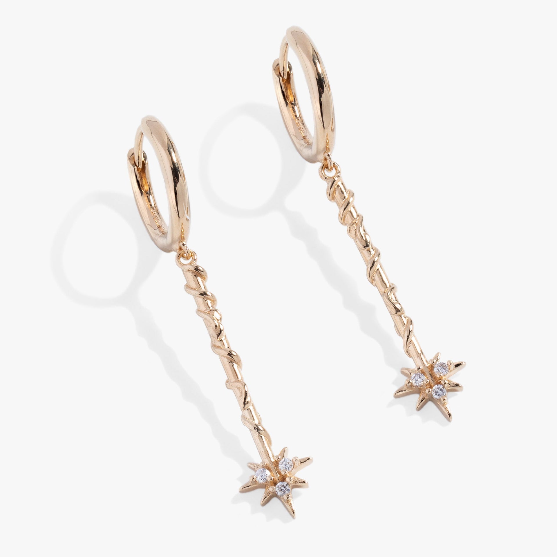 Close-up of Harry Potter Hermione Granger wand hoop earrings with crystal magic bursts.