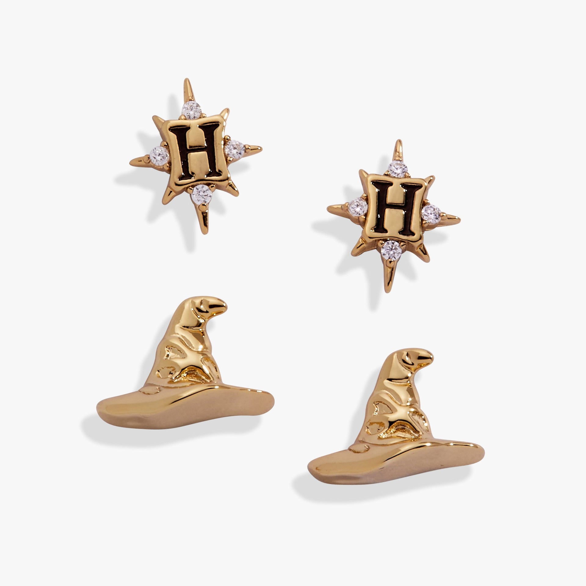 A pair of gold-plated Harry Potter stud earrings, one shaped as a 3D Sorting Hat and one as a crystal-adorned Hogwarts crest.