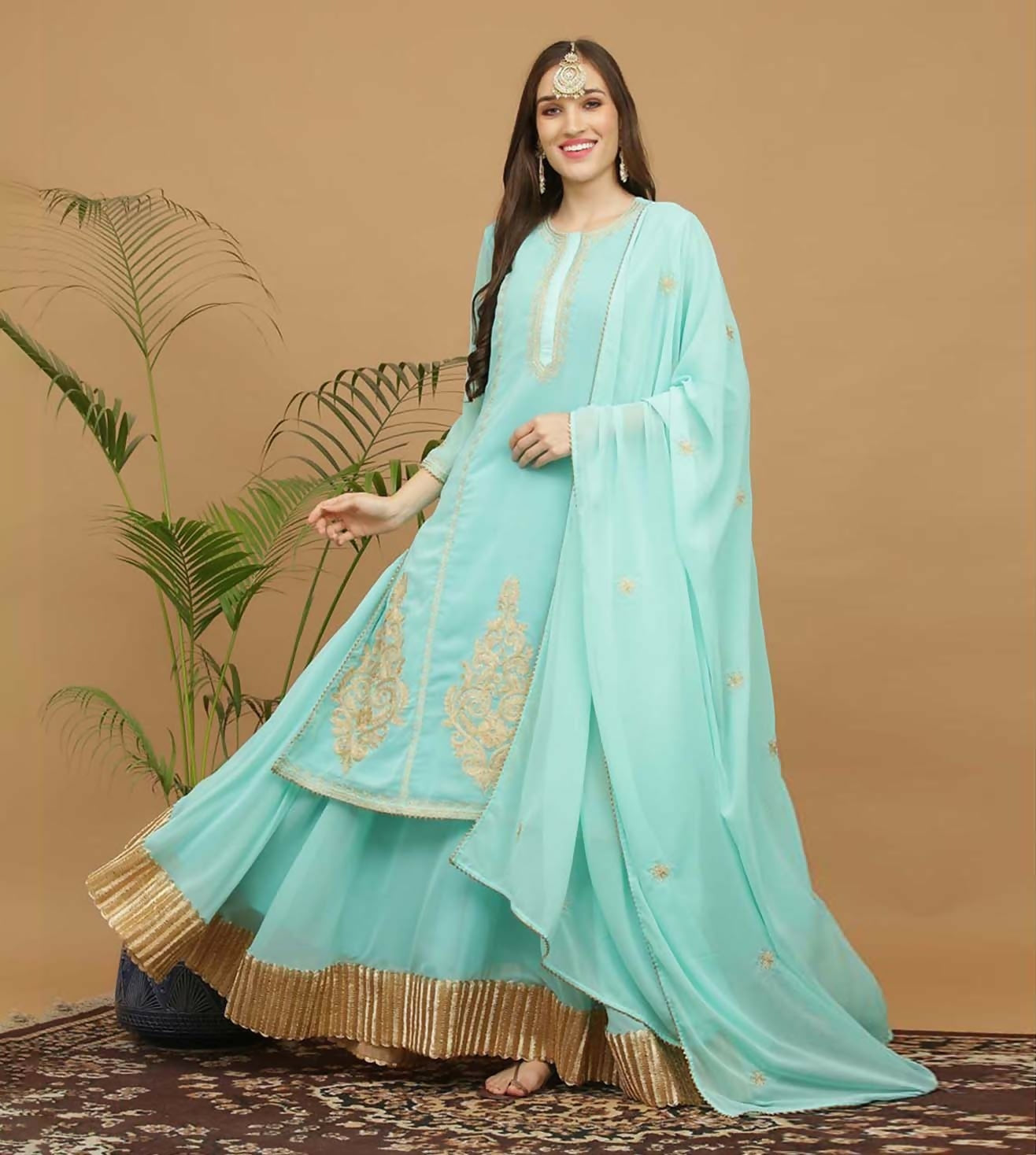 Model wearing a vibrant turquoise georgette lehenga set with elegant draping for wedding festivities.