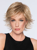 Woman wearing a modern spiky cut synthetic wig in blonde, featuring a comfortable basic cap.