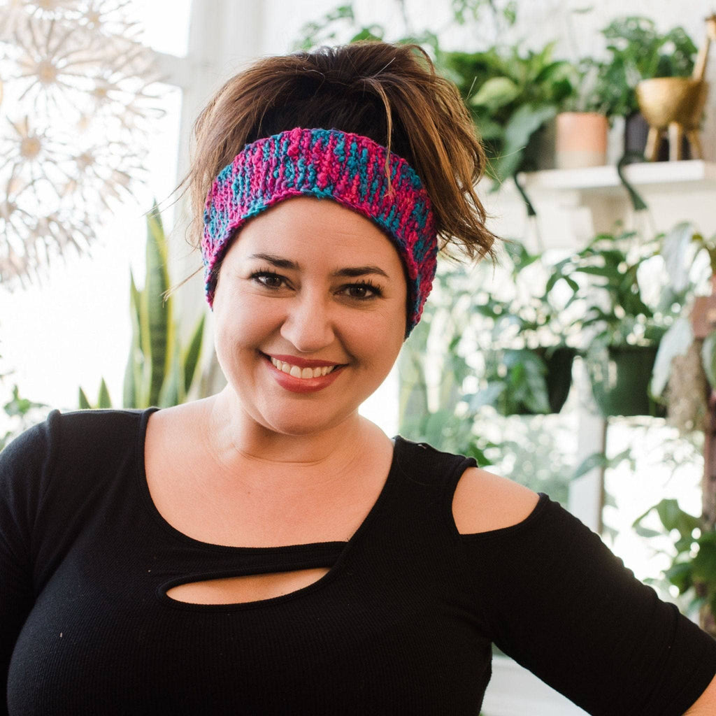 Close up of a handcrafted knit headband in pink and blue yarn