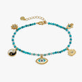 Close up of Healing Stone Charm Anklet with turquoise beads, sun, lotus, hamsa, and evil eye charms.