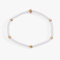 Elegant stretch bracelet featuring white faux pearls and gold-plated puffy hearts.