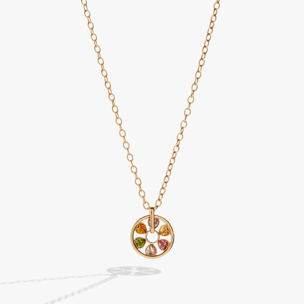 Close-up of a heart-shaped wheel necklace with colorful crystals on a delicate cable chain.
