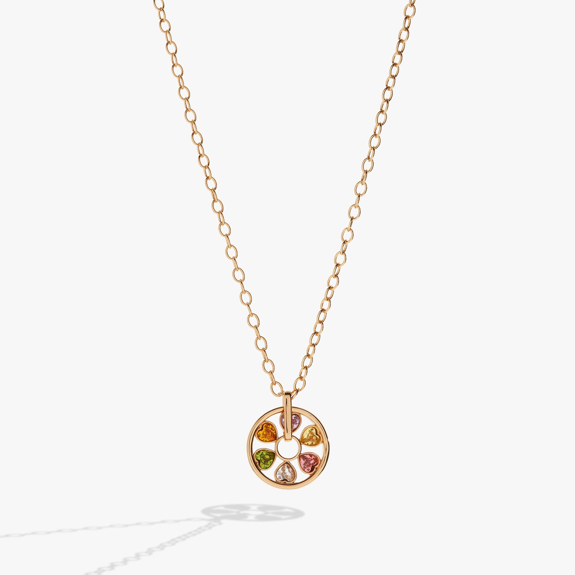 Close-up of a heart-shaped wheel necklace with colorful crystals on a delicate cable chain.