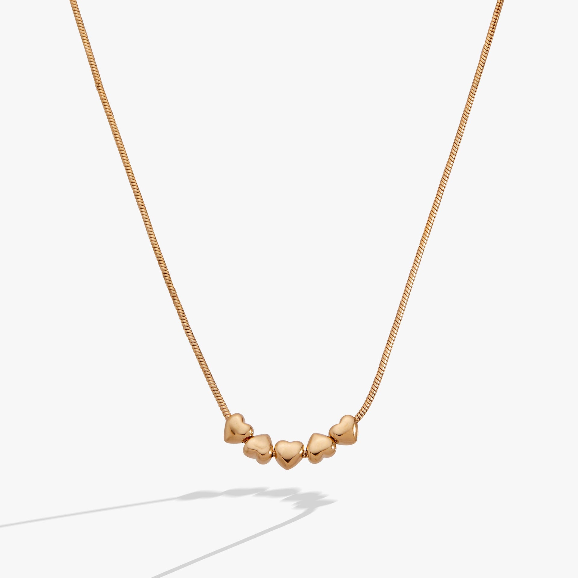 Heart slider necklace featuring five gold-plated hearts on a silky snake chain.
