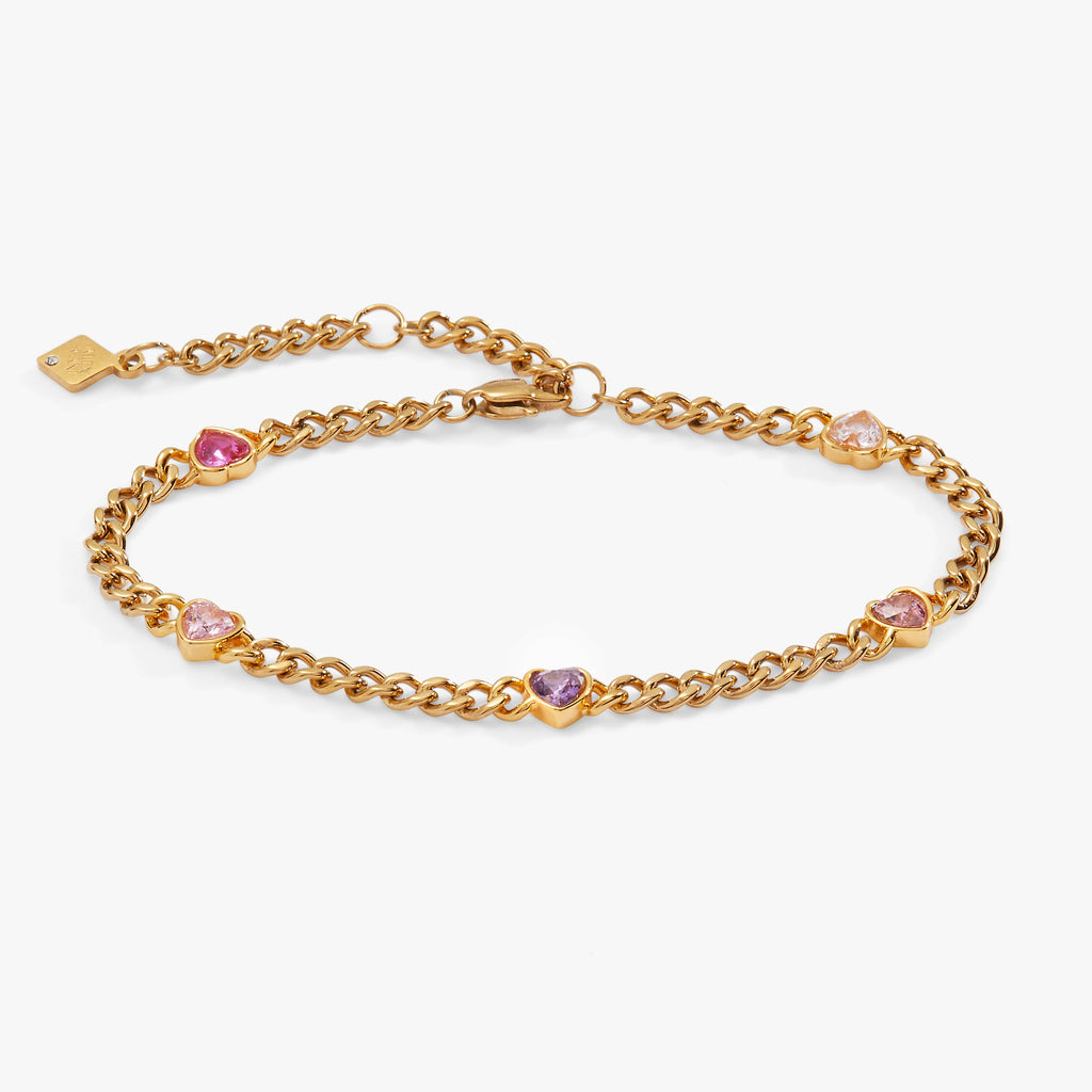 Gold-tone curb chain bracelet with five crystal-accented hearts in pink, purple, and red.