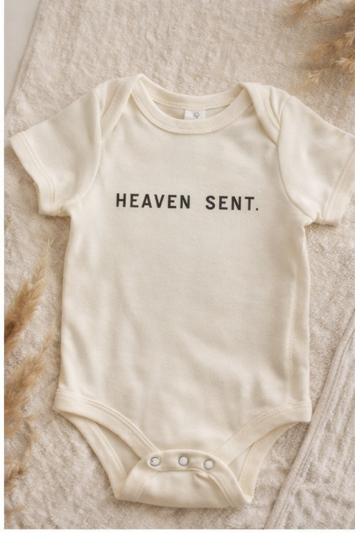 Minimalist Heaven Sent baby onesie in off-white and black colorways.