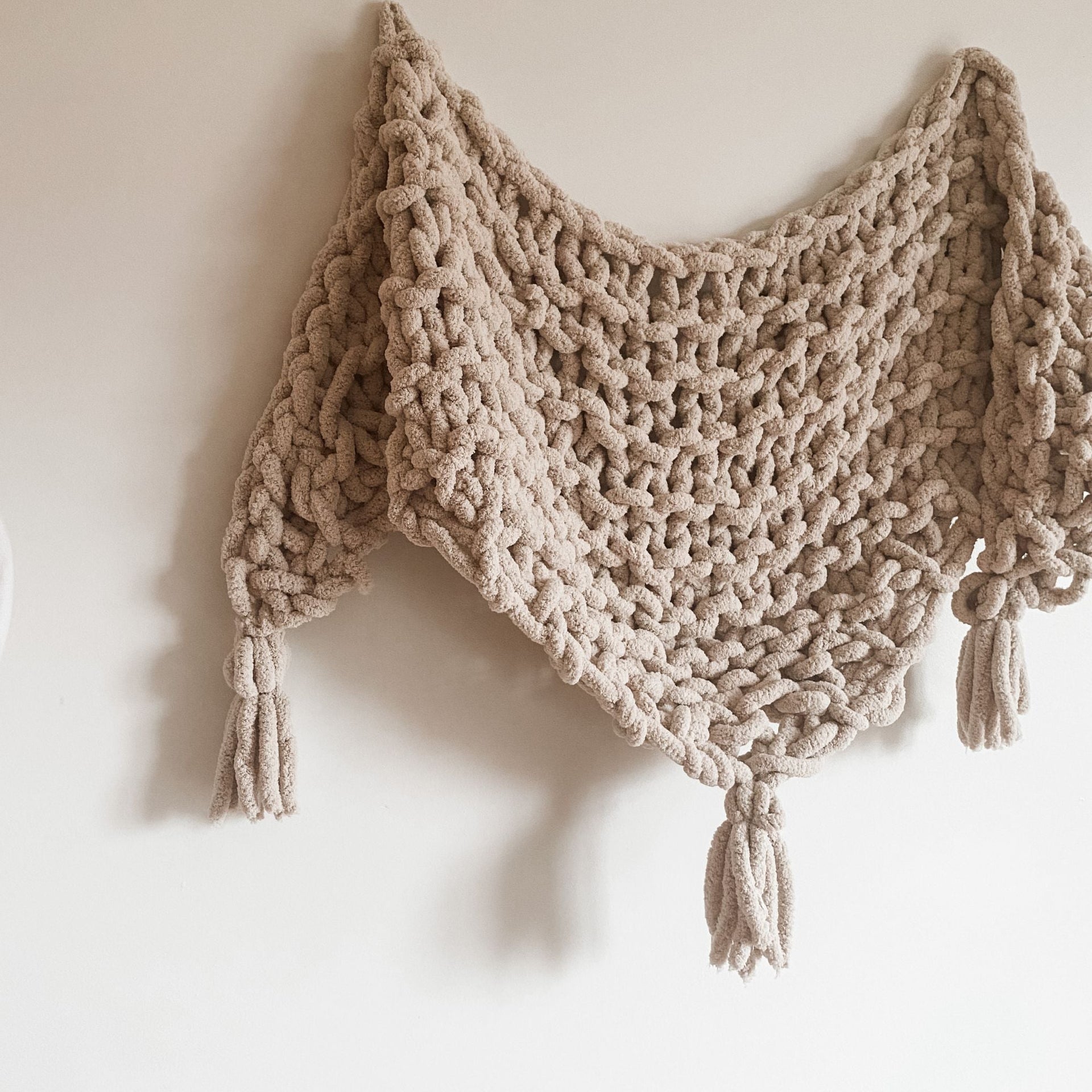 A close-up of a chunky, textured hand-knitted shawl made using the Hickory Tree Arm Knit Pattern.