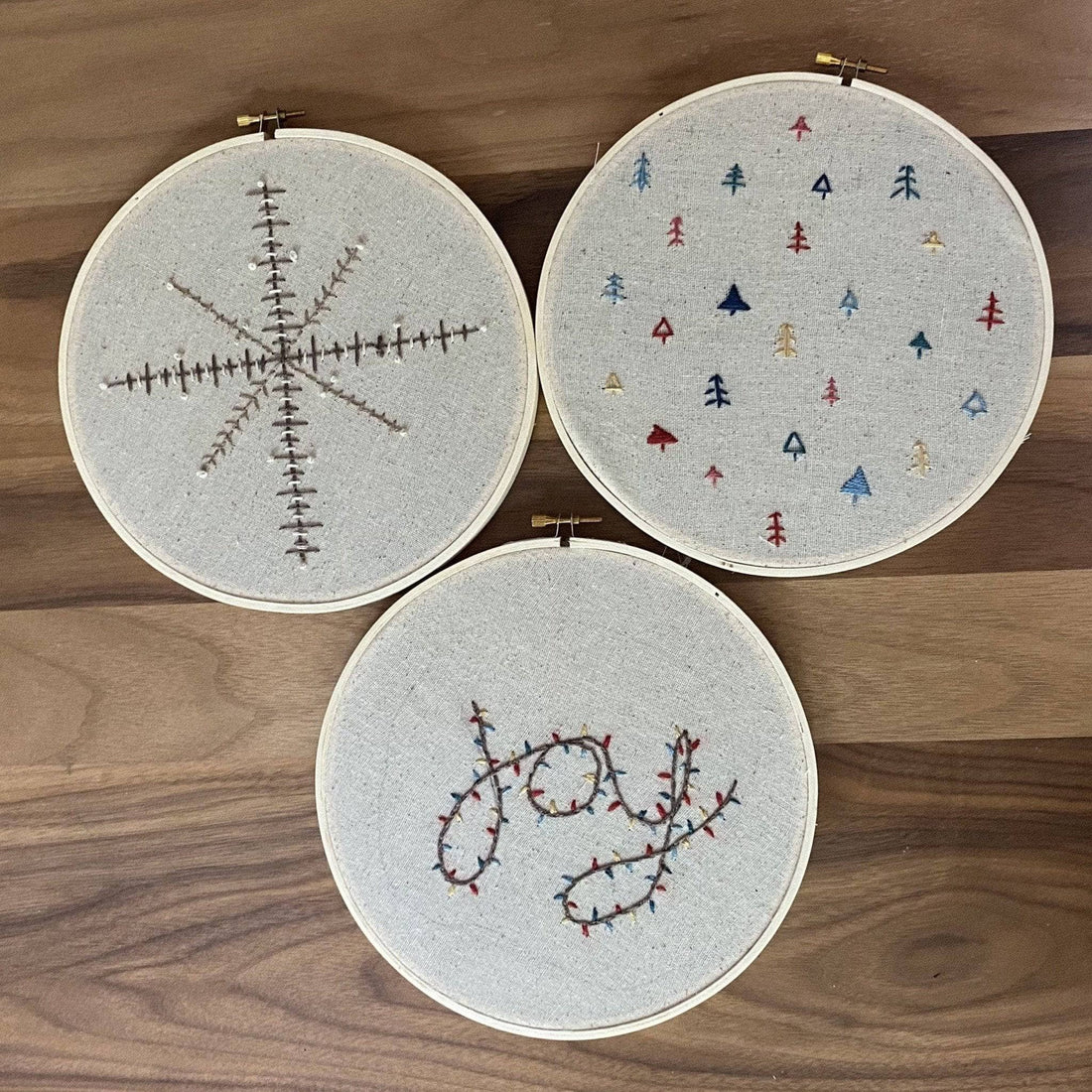 Holiday Joy, Forest and Snowflake embroidery patterns arranged for a DIY craft project.