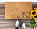 Hope You Called First text on a tan coir doormat with black lettering