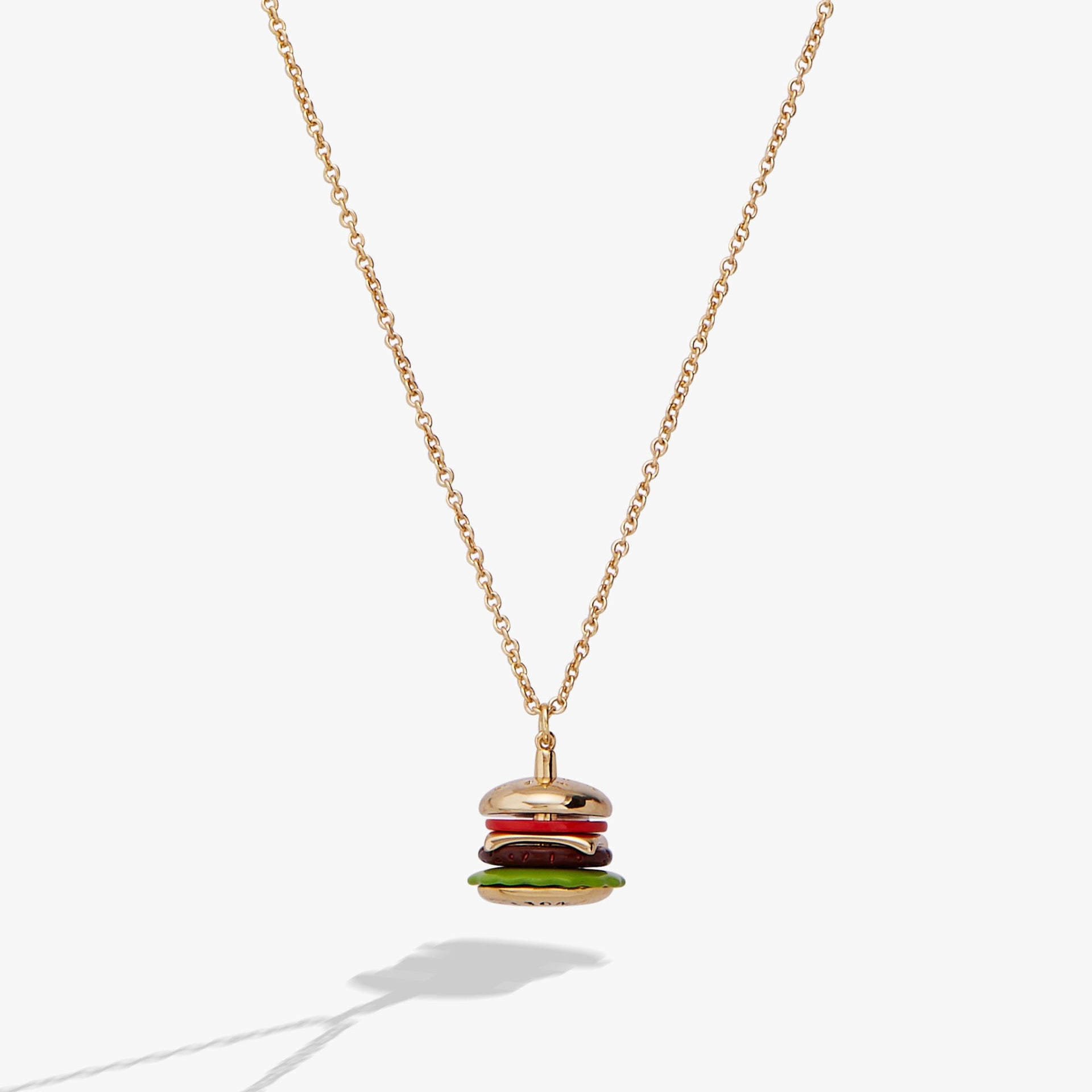 Close up of a hamburger shaped pendant charm with vibrant enamel on a gold cable chain.