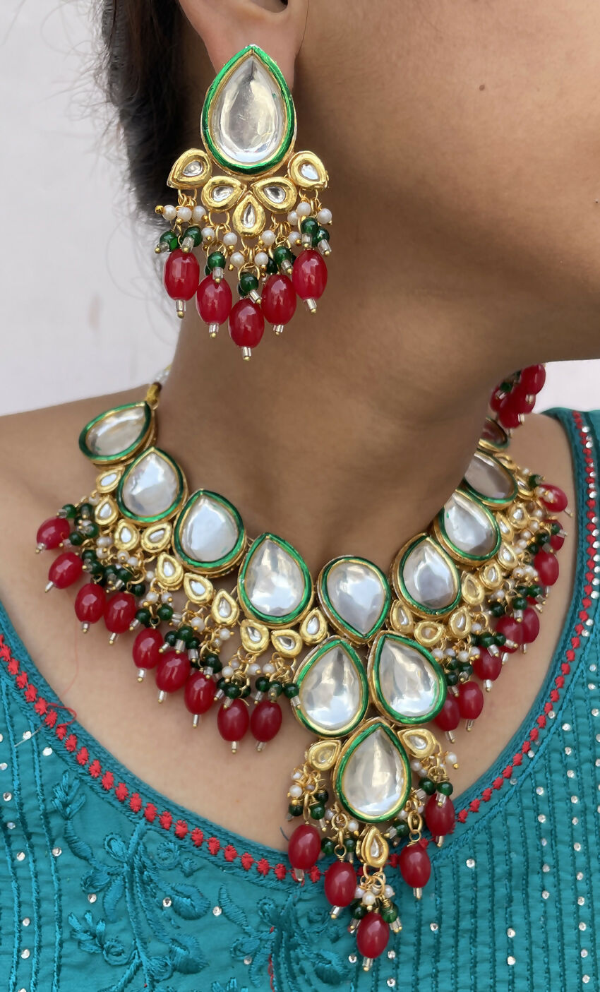 Handcrafted gold plated Kundan necklace set with stone studs on a neutral background