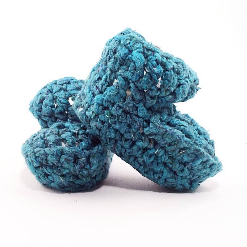 Close up of hand-knit baby booties in rich jewel tones of teal, purple, and mahogany brown.