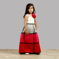 A stylish girls dress with a white bodice and a quilted multicolor skirt featuring black accents.
