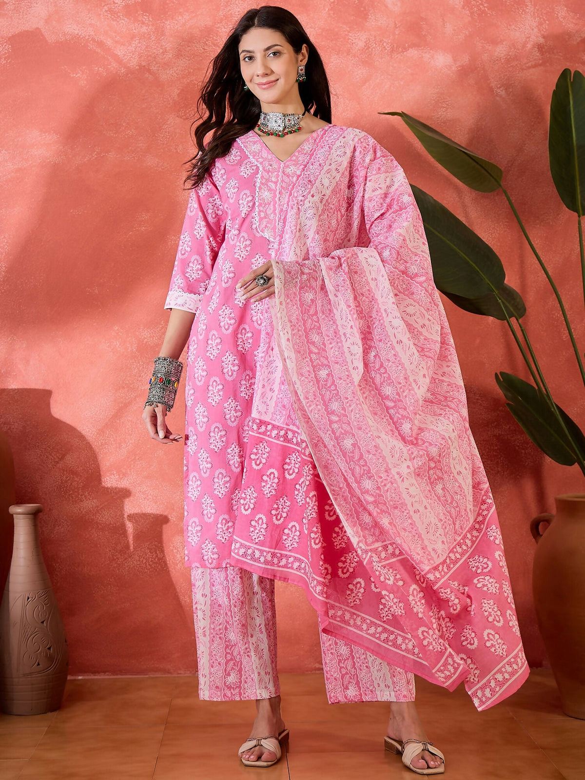 A woman wearing a stylish pink printed pure cotton kurta set with a traditional aesthetic.