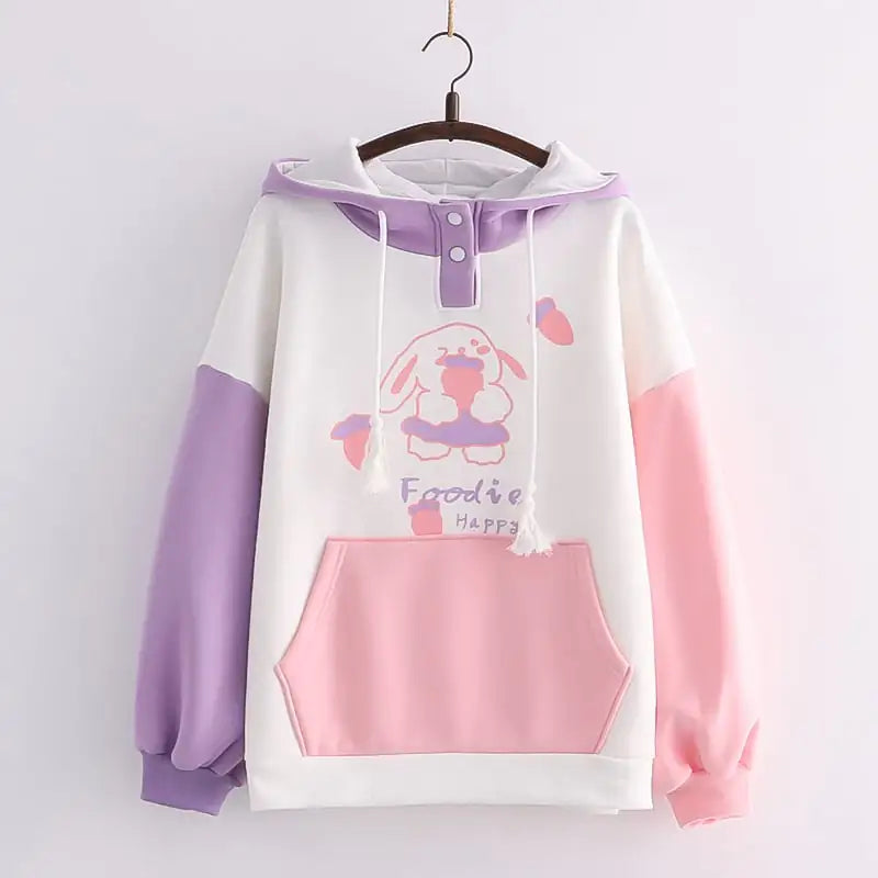Women's colorblock fleece hooded sweatshirt with graphic print and large front pocket in pink and purple.