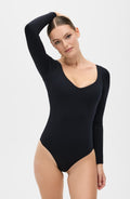 Woman wearing a black iconic compression long sleeve bodysuit with a sleek, minimalist fit