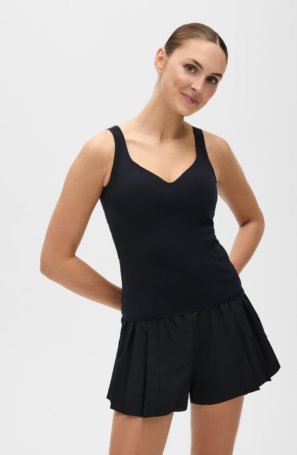 Woman wearing black Iconic MicroPerle Tank with sculpting fit and elegant neckline.
