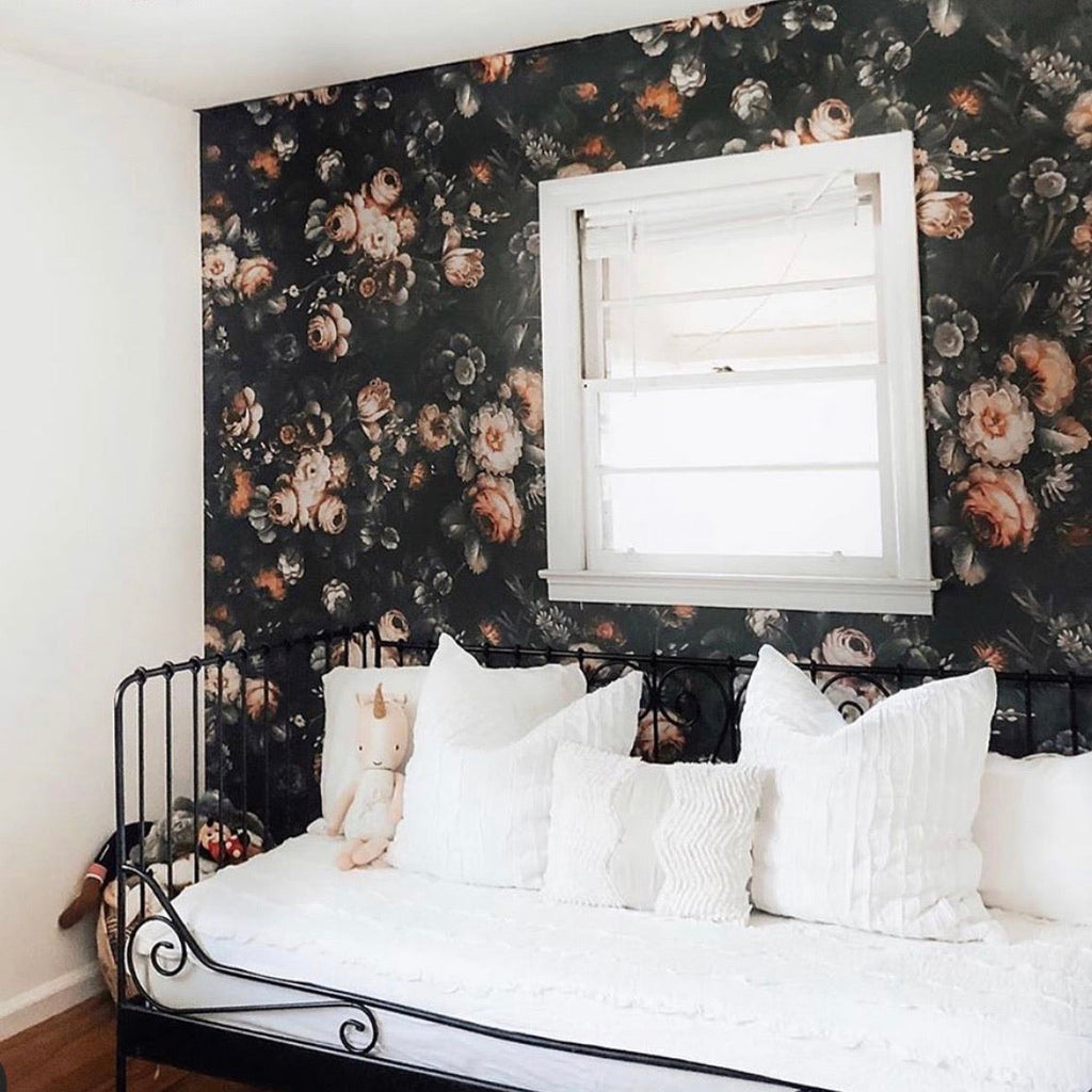 Vintage-inspired floral wallpaper featuring black, dusty-rose, and muted-green botanical prints on a wall.