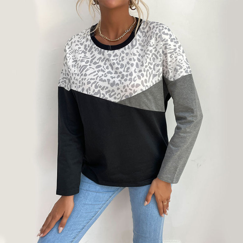 Woman wearing a color-block leopard print long-sleeve sweatshirt with grey and black panels.