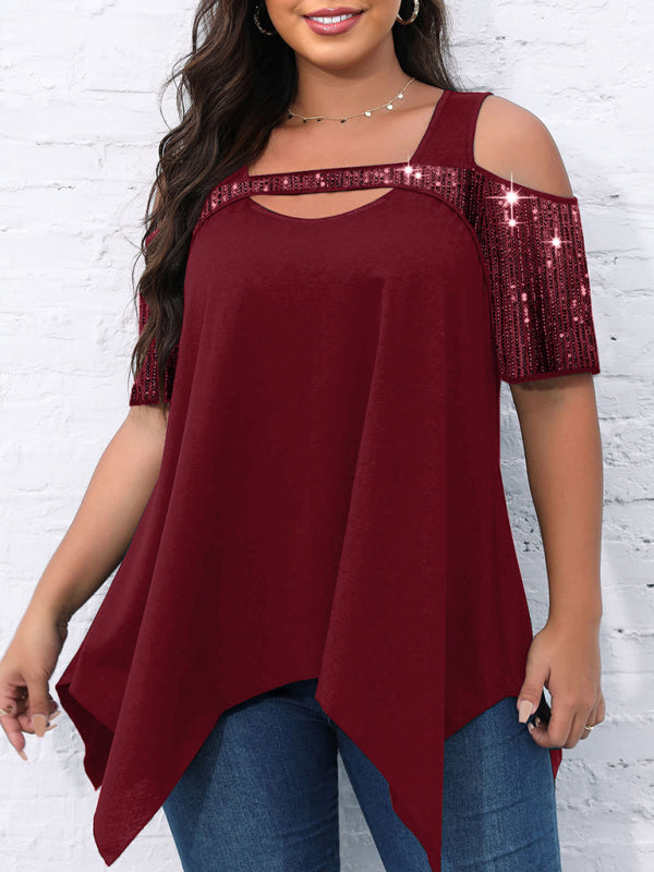 A woman wearing a burgundy cold shoulder T-shirt with sequin-adorned sleeves and an irregular wide hem.